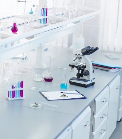 Glassware, microscope and clipboard in scientific laboratory